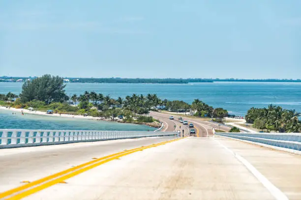 Sanibel Island, USA bay during sunny day, toll bridge highway road causeway, turquoise water, cars