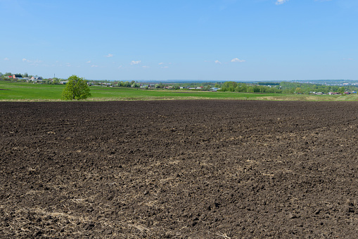 rural landscape with a village and a plowed field