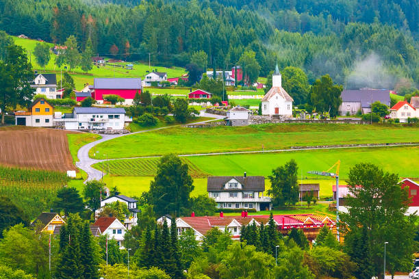 Norwegian village landscape with meadows, mountains, church and colorful houses. Loen, Norway