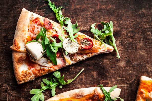 istock Hot pizza slice with Pepperoni, melting cheese on a rustic wooden table closeup.  Pizza Ready to Eat. Top view