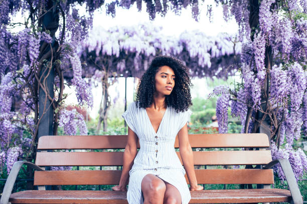 istock Young black woman sitting surrounded by flowers 1022383838