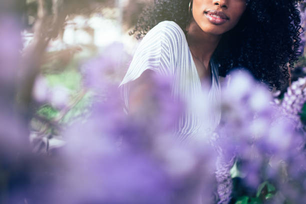 istock Young black woman sitting surrounded by flowers 1022385198