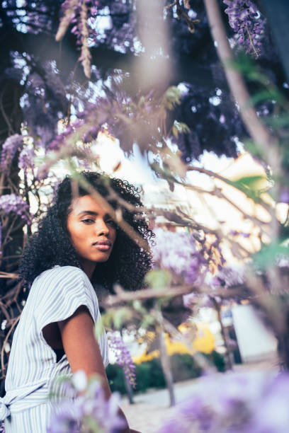 istock Thoughtful young black woman sitting surrounded by flowers 1022385846
