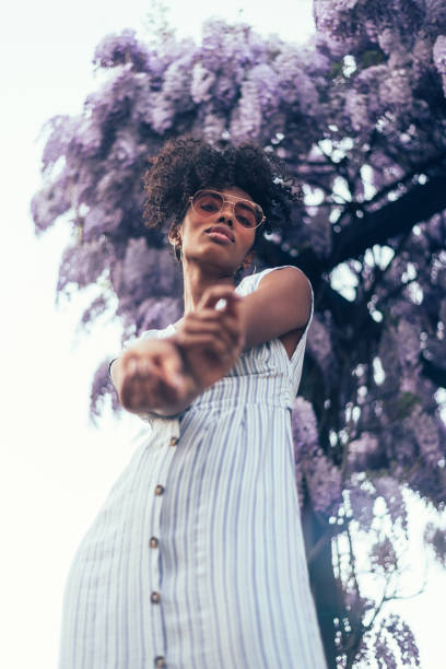 istock Happy young black woman surrounded by flowers 1022385896