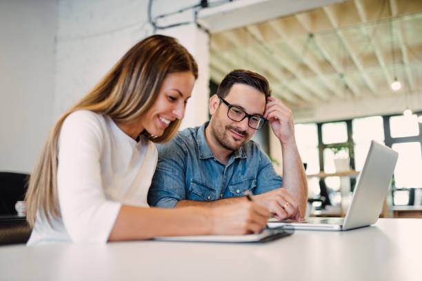istock Close-up image of two cheerful coworkers sharing ideas at work. 1022389882