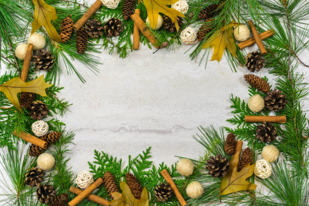 istock A border of cedar, white pine, and tamarack branches along with pine cones, cinnamon sticks, golden oak leaves, and jute and twig balls with copy space in the middle 1022397686