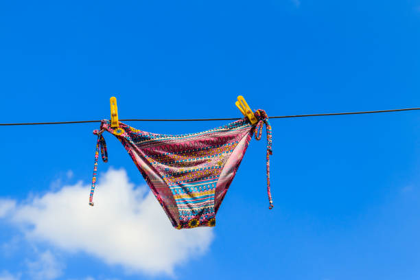 istock Drying female swimsuit hanging on a rope against blue sky 1022436254