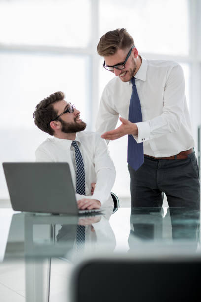 istock two employees discuss business issues near the office Desk 1022439838