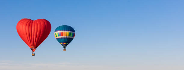 palloncini a forma di cuore rosso e colorati che volano nel cielo, striscione - inflating balloon blowing air foto e immagini stock