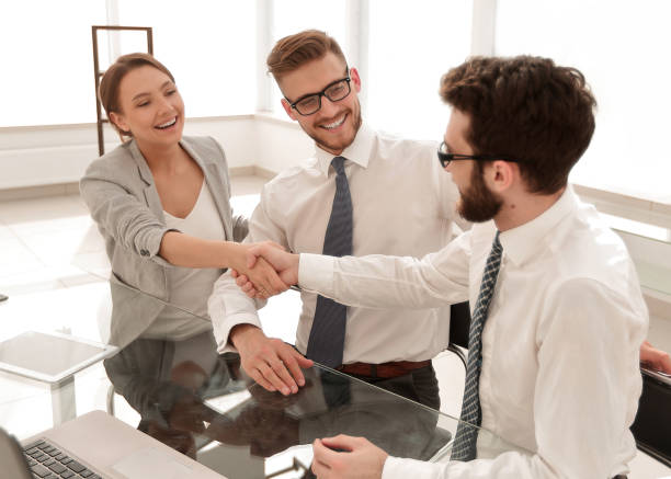 istock background image.handshakes colleagues at the Desk 1022447266