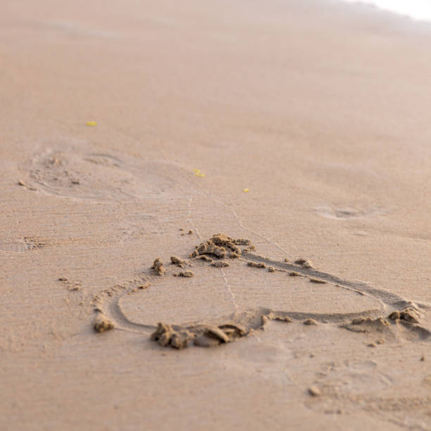 istock Heart drawn in the sand. Beach background. Top view 1022450304