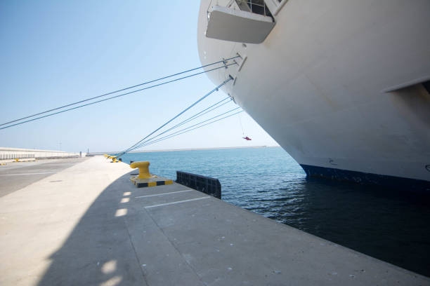 ship tethered to steel bollards on harbor wall whilst in dock