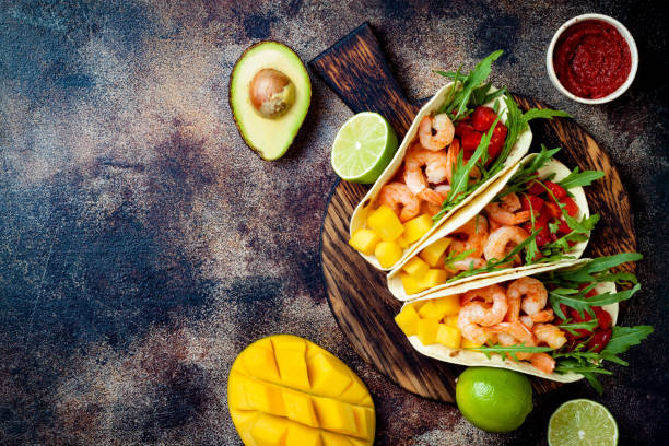 tacos mexicains crevettes avec avocat, tomates, salsa à la mangue sur table rustique en pierre. recette pour le parti de cinco de mayo. vue de dessus, au-dessus, plat poser. - sandwich avocado prepared shrimp bread photos et images de collection