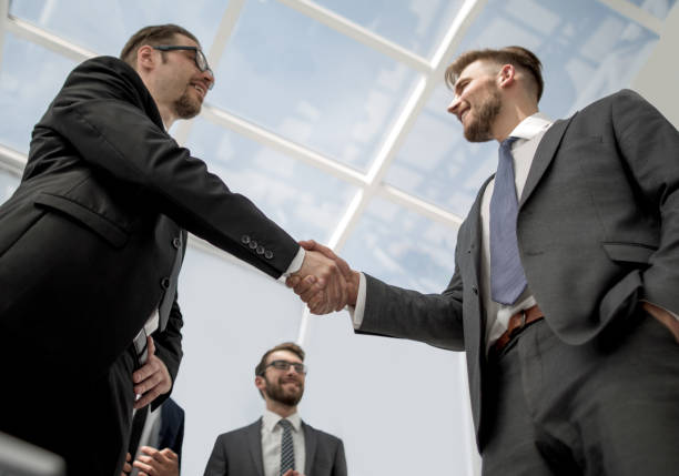 istock bottom view.smiling business people shaking hands 1022560082
