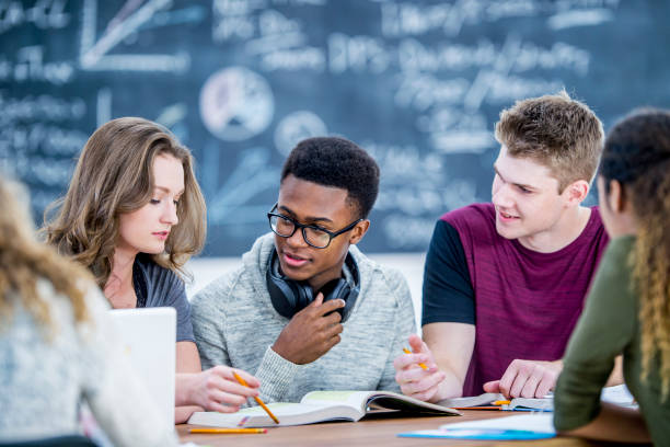 Preparing For A Test Three high school students are indoors in their classroom. They are studying for an upcoming exam. They are using a textbook to study. 16 17 years stock pictures, royalty-free photos & images