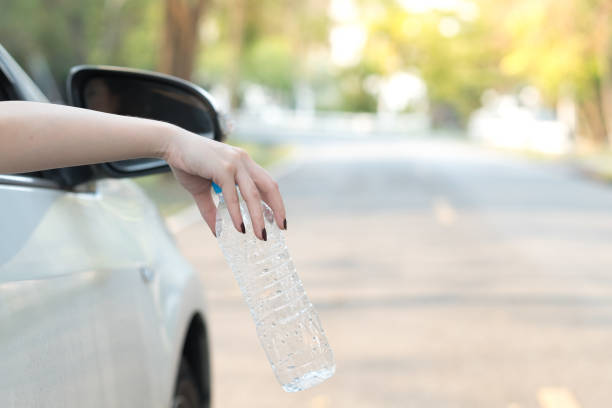 istock Hand throwing plastic bottle on the road 1022585028