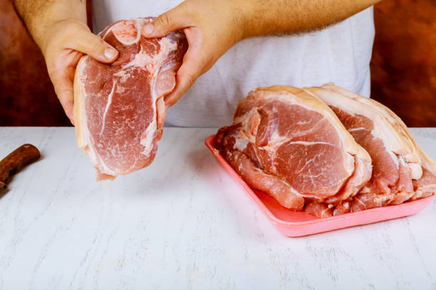 istock Butcher cutting pork meat on kitchen 1022590140
