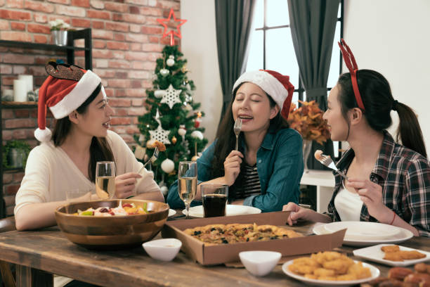 istock friends sitting and enjoying Christmas dinner 1022599784