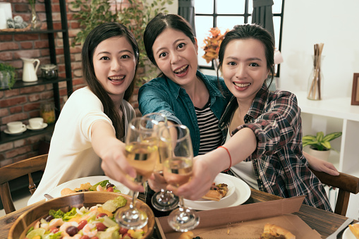 young asia girls showing clink glasses champagne and face to camera smile.