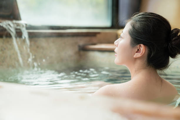 charming girl stay in hot spring water - fonte térmica imagens e fotografias de stock