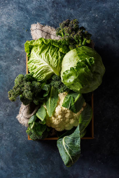 istock Cabbage in a wooden box, top view. Savoy cabbage, broccoli and iceberg lettuce. 1022623036
