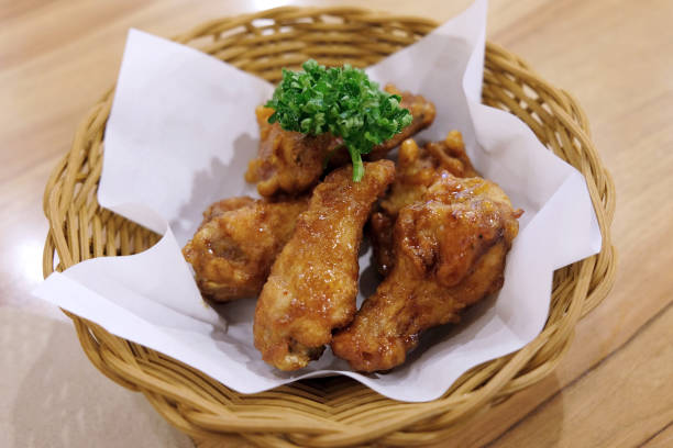 istock Fried chicken wings in white plate on wooden table. 1022625498