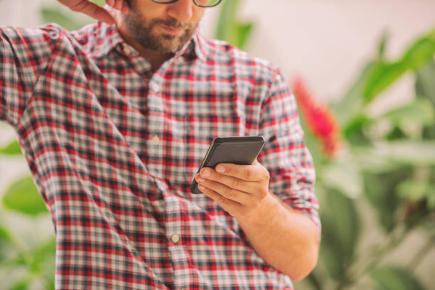 istock Modern man using cellphone in tropical garden. 1022628070