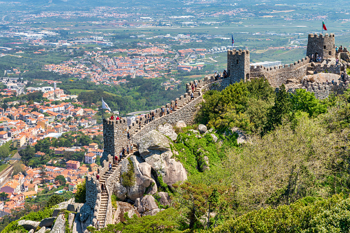 The Castle of the Moors located in the town of Sintra, near Lisbon. Photo taken during a hot summer day and contains some tourists visiting the castle.