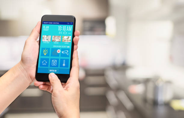 istock Hand holding mobile use smart home control mobile app at blur bokeh kitchen background,smart living concept,digital lifestyle. 1022699036