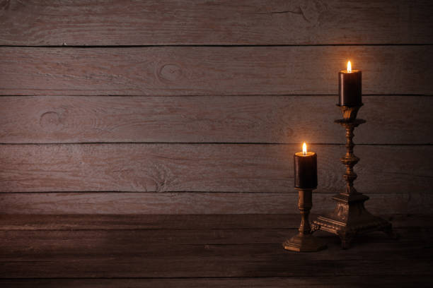 istock black burning candles in candlesticks on old wooden background 1022710286
