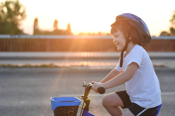 istock Happy boy riding bike at sunset 1022720988