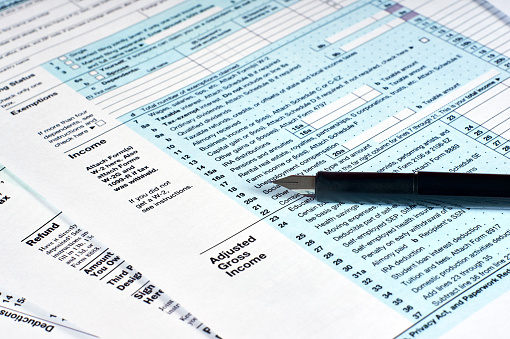 Tax reporting and pen. Filling out tax forms