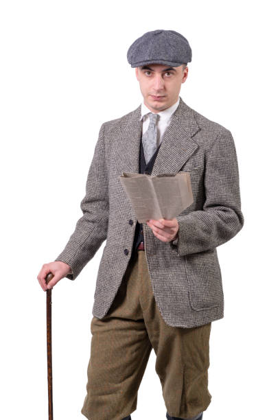 istock young man in vintage clothes with hat, reading a newspaper, 1940 style 1022726984