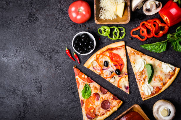 istock selection of Assorted pieces pizza on black background and ingredients. Pepperoni, Vegetarian and Seafood Pizza 1022738850