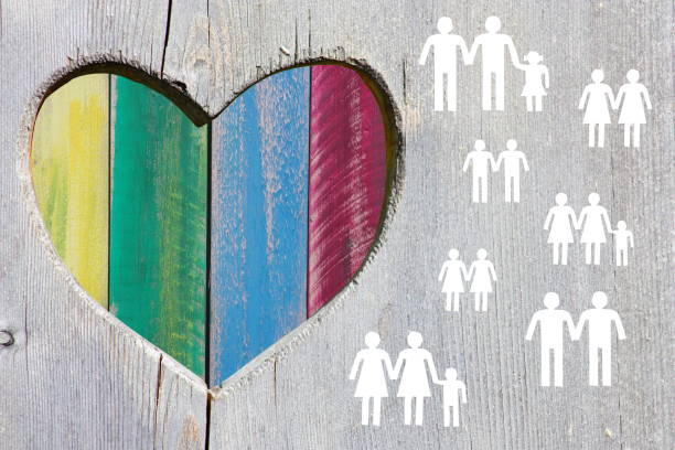 Gay and lesbian couples and families on wooden background with multicolor rainbow heart stock photo