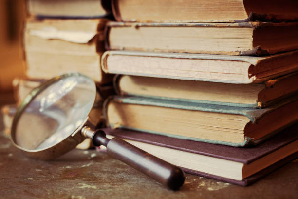 istock Antique books with magnifying glass. 1022749594