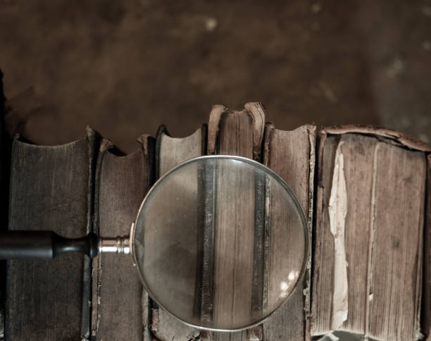 istock Antique books with magnifying glass. 1022749930