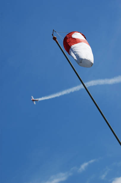 istock Windsock and aerobatic aircraft in blue sky 1022750940