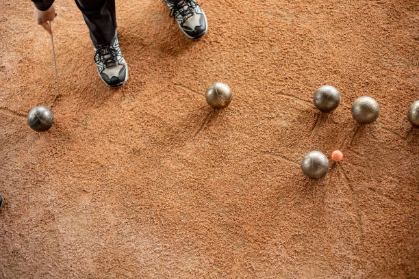 ältere frau markieren, wo die bocciabahn stehen geblieben ist - pétanque stock-fotos und bilder