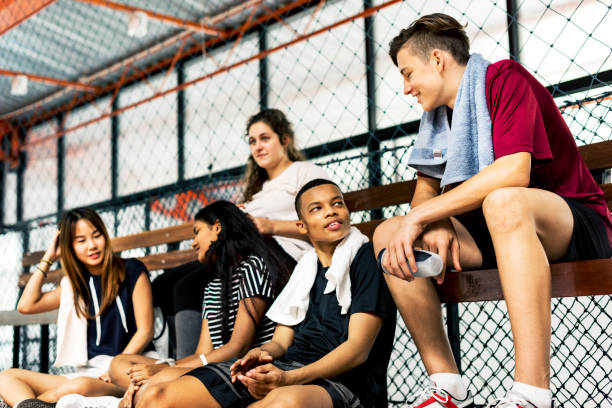 gruppo di giovani amici adolescenti seduti su una panchina rilassanti - hanging basket foto e immagini stock