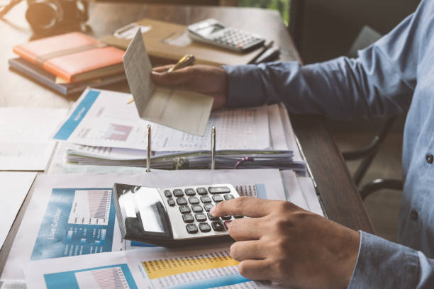 istock Business man hands holding saving account passbook and using calculator to calculate budget planner, Business finances and Saving concept. 1022781854
