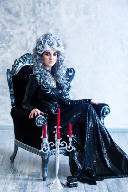 halloween sorcière en robe noire - fauteuil baroque photos et images de collection