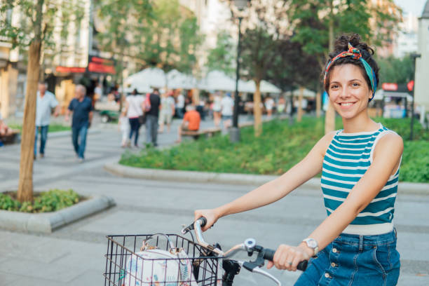 istock Young woman sitting on a bicycle and smiling 1022790846