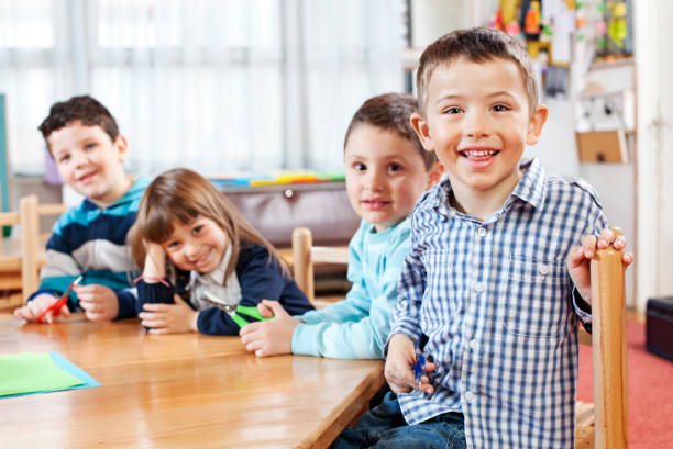 istock Smiling children sitting in a kindergarten 1022800702