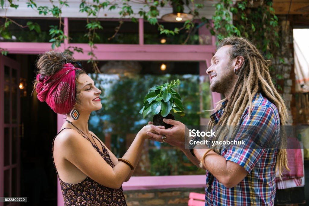 Pareja De Hippies Amantes Teniendo Plantita Verde A Su Casa Foto de stock y  más banco de imágenes de Adulto - iStock