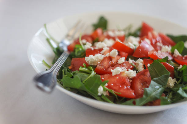 istock Tomato salad with basil, cheese, olive oil and garlic dressing on white background 1022801124