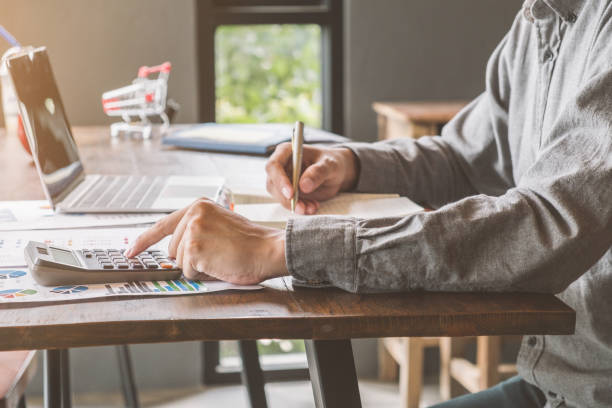 istock Business accounting, Businessman using calculator with  budget document,pen,laptop and notebook in office, Savings, finances and economy concept. 1022801418