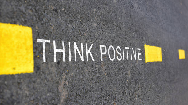 istock Words of Think positive with yellow line marking on road surface 1022801444
