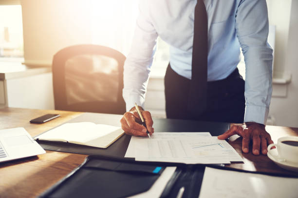 istock Businessman leaning on his office desk signing financial documents 1022804796