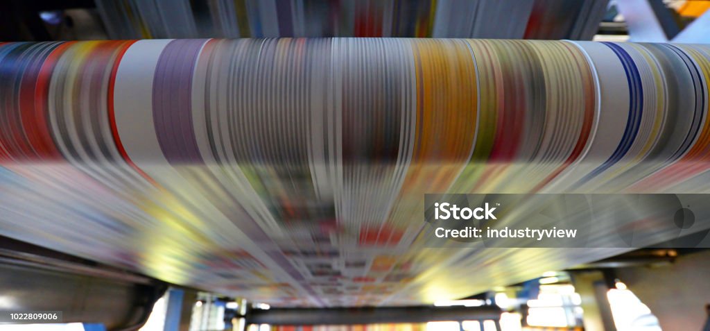 printing of coloured newspapers with an offset printing machine at a printing press roll offset print machine in a large print shop for production of newspapers & magazines Printing Press Stock Photo